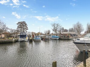 A marina with boats docked, a wooden dock, and a building in the background.