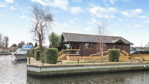A riverside building with a dock, a staircase, and a small deck area.