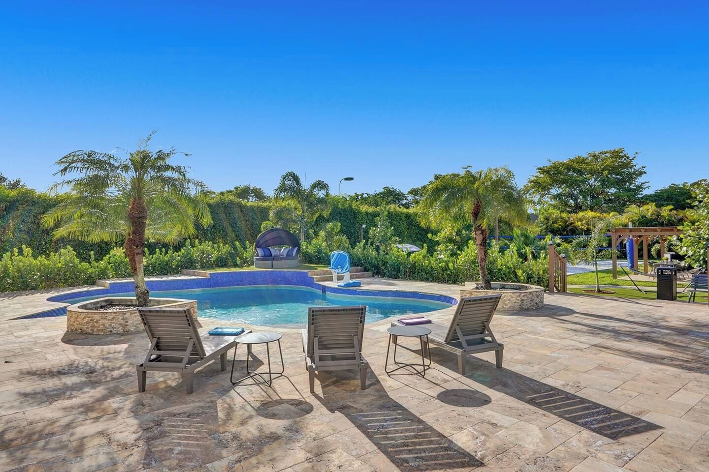 Un espace piscine avec des chaises longues et un jacuzzi.