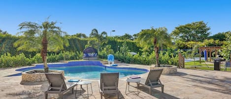 Un espace piscine avec des chaises longues et un jacuzzi.