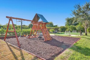 A playground with a climbing structure, swings, and a slide. - Lavish 8 Br Estate with Pool & Courts (Plantation)