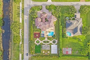 An aerial view of a residential property with a swimming pool, tennis courts, and a landscaped garden. - Lavish 8 Br Estate with Pool & Courts (Plantation)