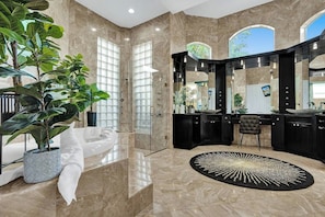 Une salle de bain moderne avec une baignoire, un grand miroir et un lavabo.