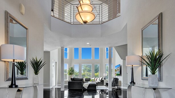 A spacious foyer with a high ceiling, large windows, and a central seating area. - Lavish 8 Br Estate with Pool & Courts (Plantation)