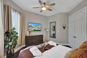 A hotel room with a bed, a ceiling fan, a television, a mirror, and a plant. - Lavish 8 Br Estate with Pool & Courts (Plantation)