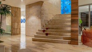 Een modern interieur met een marmeren trap, een groot raam met een abstract blauw uitzicht en een houten accentmuur.