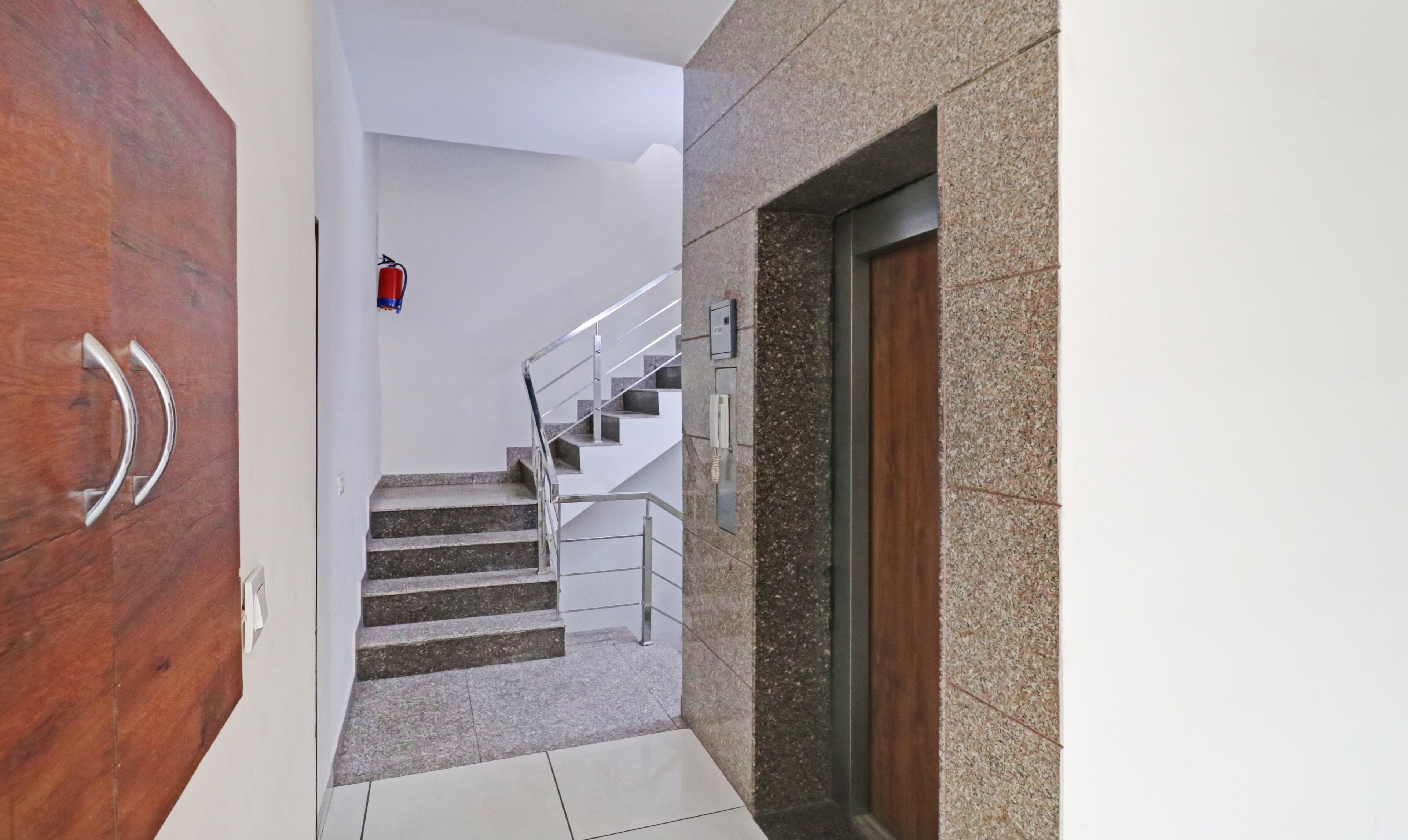 A staircase with metal railings and a fire extinguisher on the wall.