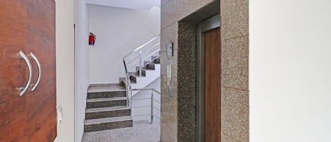 A staircase with metal railings and a fire extinguisher on the wall.