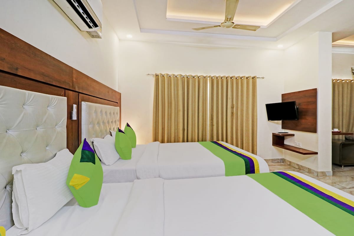 A hotel room with a large bed, a television, and a desk with a chair.