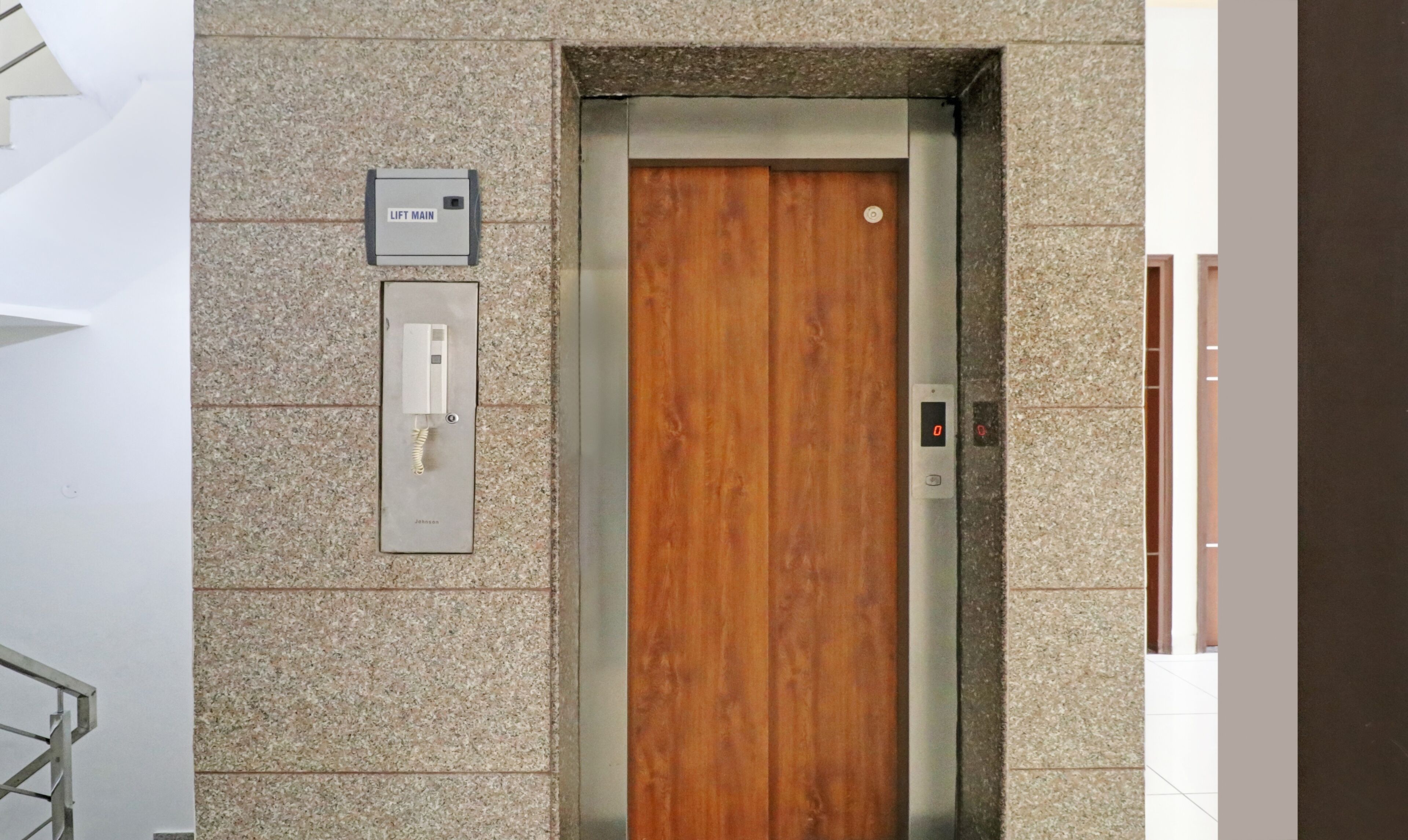 Un ascensor con puerta de madera y panel de control en la pared.