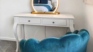 A white desk with a gold-framed mirror, two drawers, and a teal chair. - 2 bedroom accommodation in Caythorpe, near Nottingham (Caythorpe, near Nottingham)