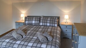 A bedroom with a bed, two bedside tables with lamps, and a nightstand. - 3 bedroom accommodation in Kyle of Lochalsh (Kyle of Lochalsh)