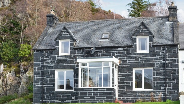 A stone house with a gabled roof, a bay window, and a small porch. - 3 bedroom accommodation in Kyle of Lochalsh (Kyle of Lochalsh)