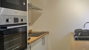A kitchen with a built-in oven, microwave, and a stainless steel sink. - 3 bedroom accommodation in Kyle of Lochalsh (Kyle of Lochalsh)