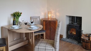 A dining table set with plates, glasses, and a vase of flowers. - 3 bedroom accommodation in Kyle of Lochalsh (Kyle of Lochalsh)