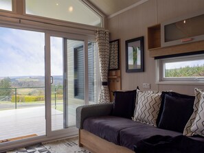 Una sala moderna con sofá, un ventanal y vistas al exterior.