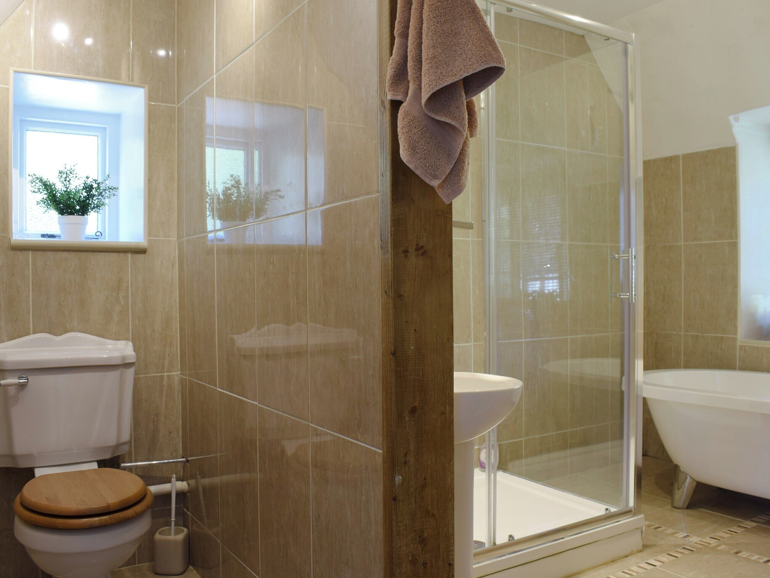 A bathroom with a toilet, sink, shower, and bathtub.