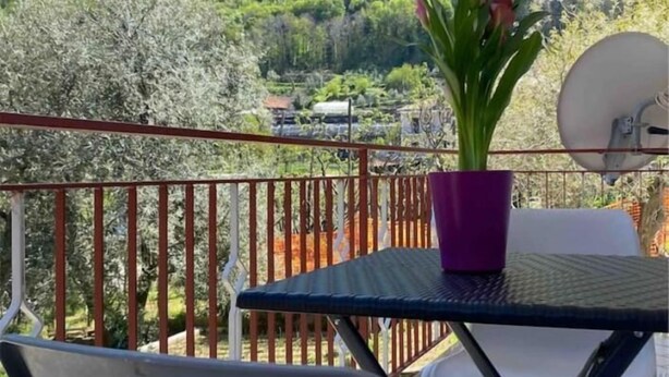 A balcony with a table, chairs, a potted plant, and a satellite dish. - Casa Antonia-in a strategic area to visit the main attractions of Naples (Piazza-Tralia-Pendolo)