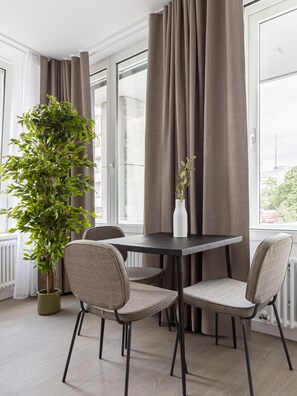 A modern dining area with a table, chairs, and a potted plant. - Limehome Berlin Luise-Henriette-Str. (Berlin)