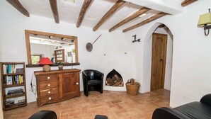 A cozy living room with a fireplace, wooden furniture, a bookshelf, and a mirror. - Casa Verde - sleeps up to 4 (Bordeira)