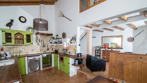 A kitchen with green cabinets, a wooden dining table, and a bowl of lemons. - Casa Verde - sleeps up to 4 (Bordeira)