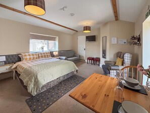 Une chambre à coucher avec un lit, une table de chevet, une lampe et une fenêtre avec des stores.