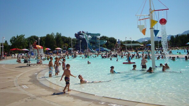 A public swimming pool with multiple water slides and a water park area. - Willow Park House on Fairway Ln (Logan)