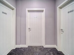 Un pasillo con dos puertas blancas, cada una con un número y un nombre.