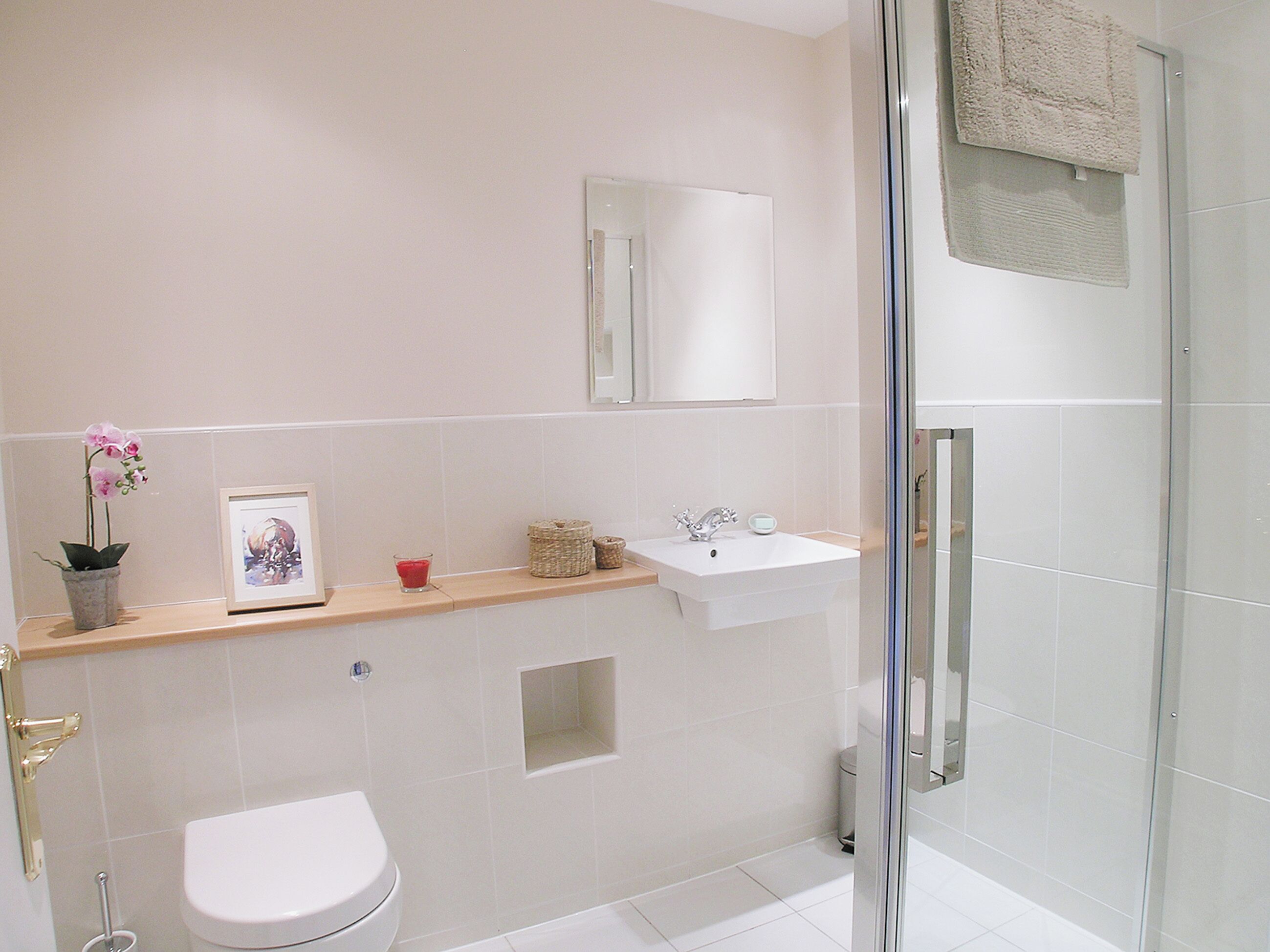 Ein Badezimmer mit Toilette, Waschbecken, Spiegel und Dusche.
