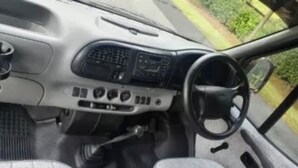 A car interior with a manual transmission, a steering wheel, and a center console with various controls. - Camper 8 “Bertha” (Leinster)