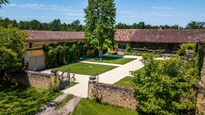 A courtyard with a gravel path, a grassy area, and a wooden fence. - Manoir Gascon - Five Bedroom Villa, Sleeps 12 (Estang)