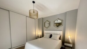 Ein modernes Schlafzimmer mit einem großen Bett, zwei Nachttischen und einer Hängeleuchte.