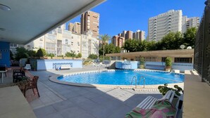 Ein Schwimmbad mit Blick auf umliegende Gebäude, darunter das Hotel Playmon Bacana.
