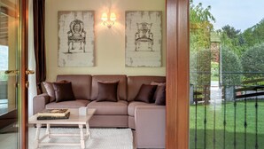 A living room with a beige sofa, a coffee table, and two wall-mounted lamps. - Villa Sonni - Four Bedroom Villa, Sleeps 8 (Bellagio)