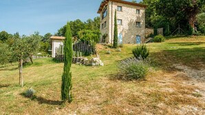 A stone building with a flat roof, surrounded by a grassy area with trees and shrubs. - Villa Todari - Three Bedroom Villa, Sleeps 10 (Torricella in Sabina)