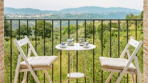 A balcony with two white chairs, a small round table, and a view of distant hills and buildings. - Villa Todari - Three Bedroom Villa, Sleeps 10 (Torricella in Sabina)