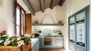 A kitchen with a wooden countertop, a built-in oven, and a window with a view of the outdoors.