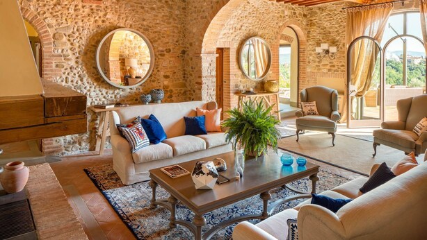 A spacious living room with a stone wall, a fireplace, a sofa, and a coffee table.