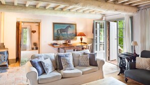 A cozy living room with a sofa, a wooden coffee table, and a painting of a horse. - Villa Tirelli - Five Bedroom Villa, Sleeps 10 (San Casciano dei Bagni)