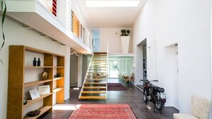 Un intérieur moderne avec un escalier, un tapis rouge et une moto.