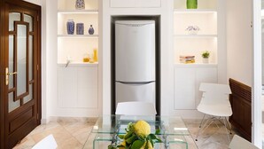 A modern kitchen with a built-in refrigerator, white cabinetry, and a glass dining table with chairs. - Villa Minerva - Three Bedroom Villa, Sleeps 10 (Sant'Agnello)