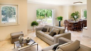 A spacious living room with a sofa, coffee table, and dining area with chairs. - Villa Minerva - Three Bedroom Villa, Sleeps 10 (Sant'Agnello)