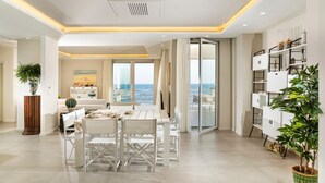 A spacious living area with a dining table, white chairs, and a view of the sea through large windows. - Villa Sul Mare - Eight Bedroom Villa, Sleeps 16 (Acireale)