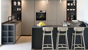A modern kitchen with a central island, bar stools, a built-in oven, and a coffee machine. - Villa Suprema - Four Bedroom Villa, Sleeps 8 (Pirato)