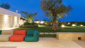 An outdoor seating area with modern furniture and a large tree. - Villa Suprema - Four Bedroom Villa, Sleeps 8 (Pirato)