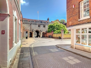 A street with a stone building, a tree, and a shop with large windows. - 2 bedroom accommodation in Winchester (Winchester)