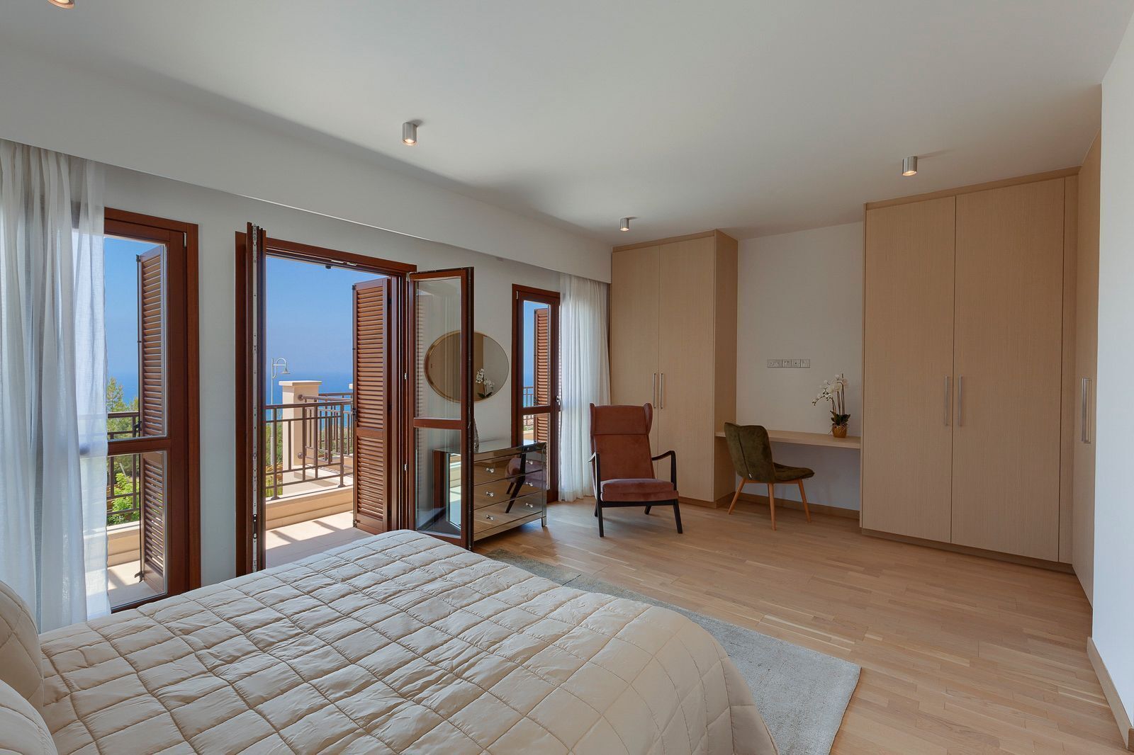 A bedroom with a bed, a desk, a chair, and a wardrobe.