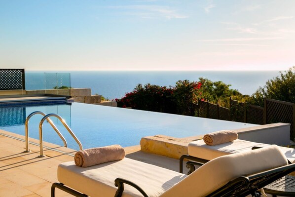 An infinity pool, pool loungers