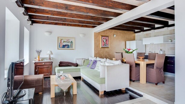 A living room with a sofa, coffee table, and a dining area with chairs and a table. - Villa Toni - Five Bedroom Villa, Sleeps 10 (Orasac)