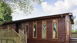 A log cabin with a wooden deck, a satellite dish, and a clear sky. - 3 bedroom accommodation in Lanreath, near Looe (Lanreath, near Looe)